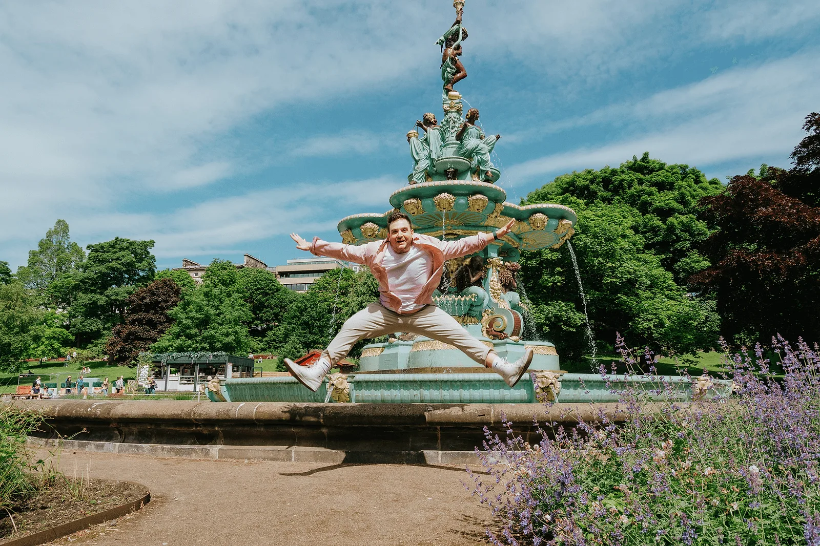 man jumping in edinburgh park during photoshoot