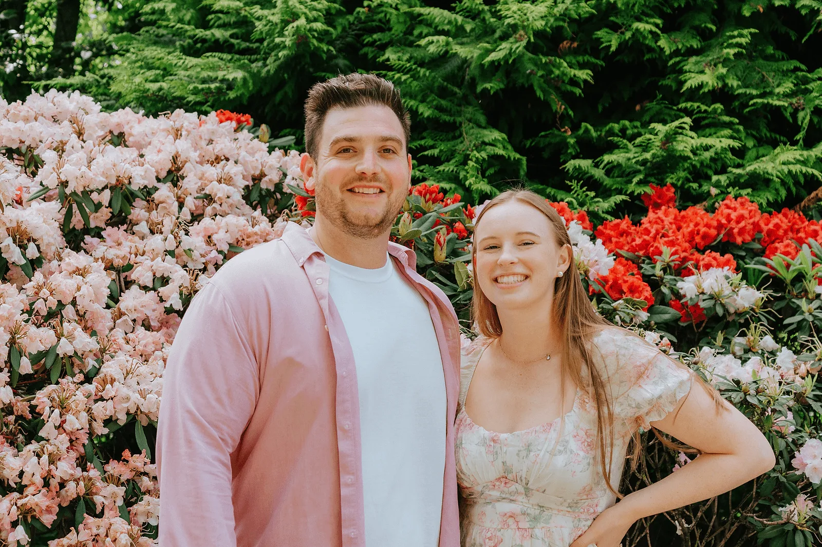 couple posing in front of blooming flowers in edinburgh 