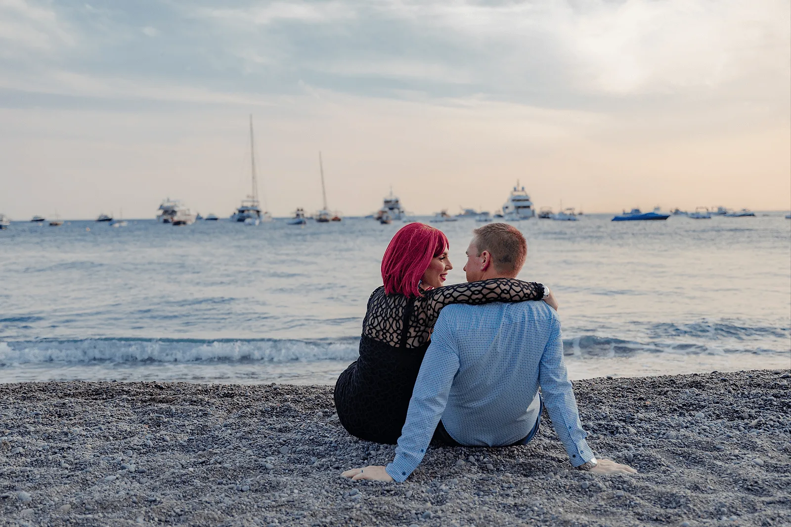 couple during golden hour sitting on the beach in positano italy