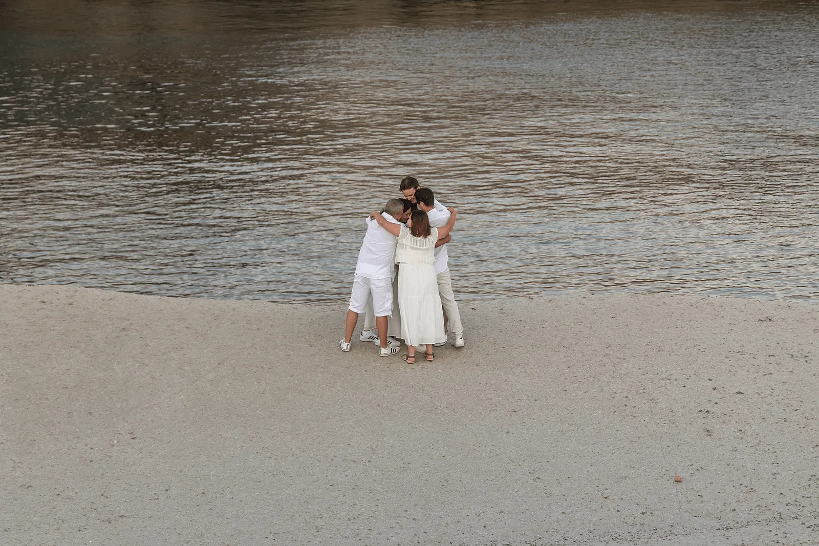 big family hug after secret proposal in milos