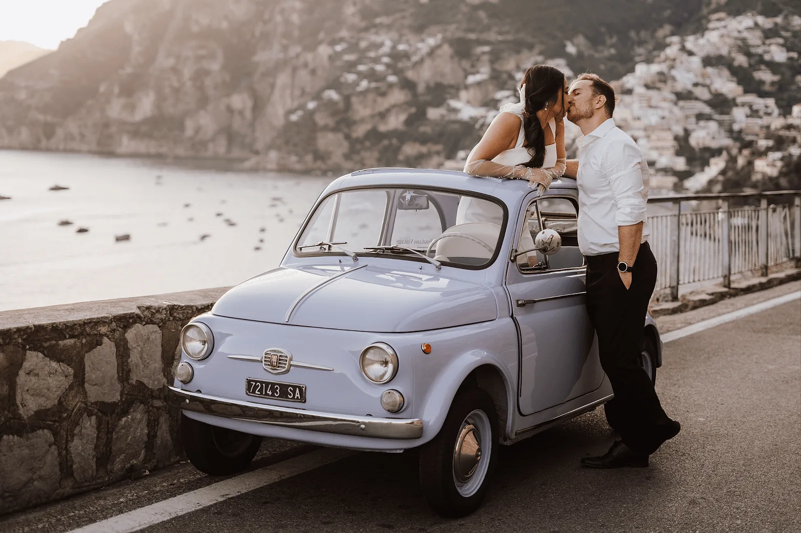 wedding photoshoot in positano italy: couple with italian retro blue car