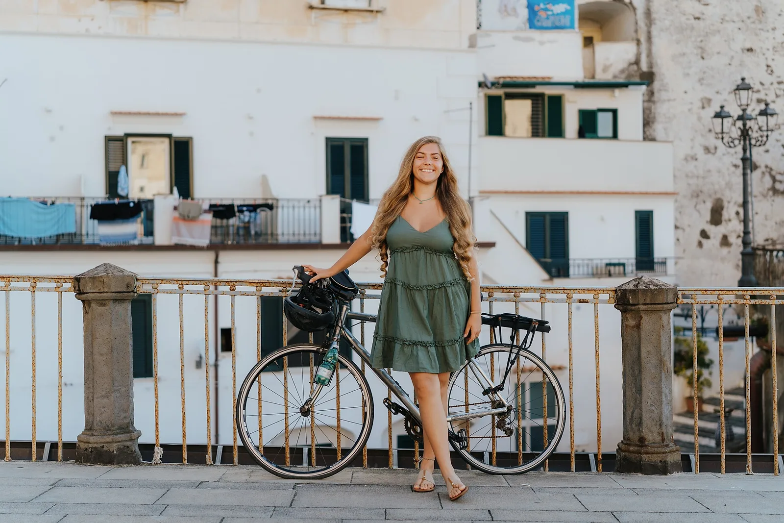 smiling woman posing with a bike at the Amalfi Coast