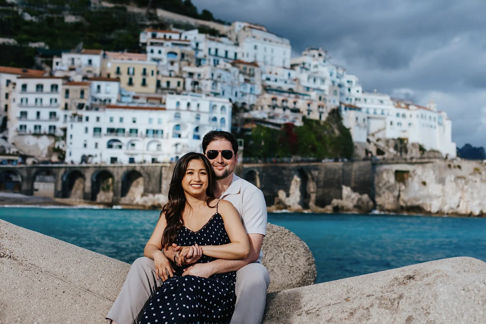 couple embracing and smiling in front of Positano
