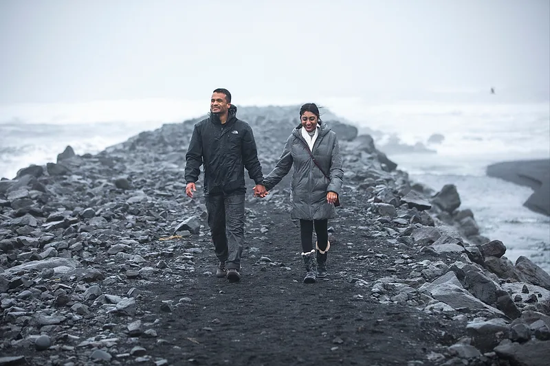 couple during rainy day on iceland black beach