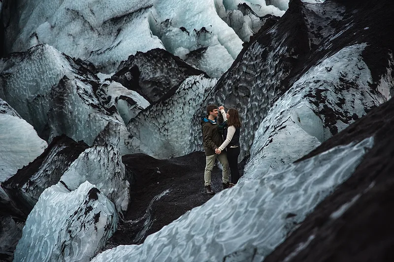 couple captured in iceland sranding in the middle of glacier