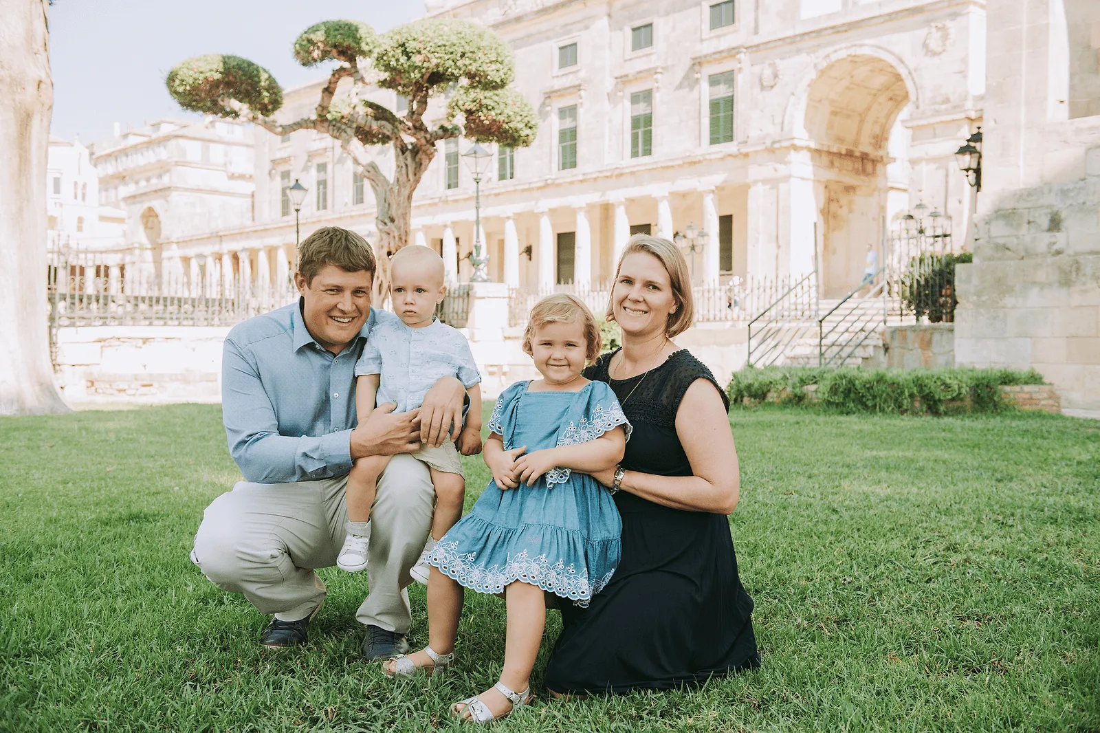 family posing in corfu, greece with two little kids in garden