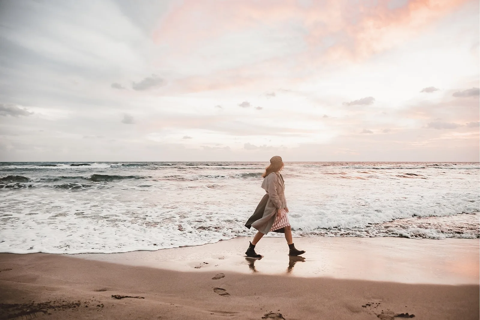 Woman walking on a beach in sunset