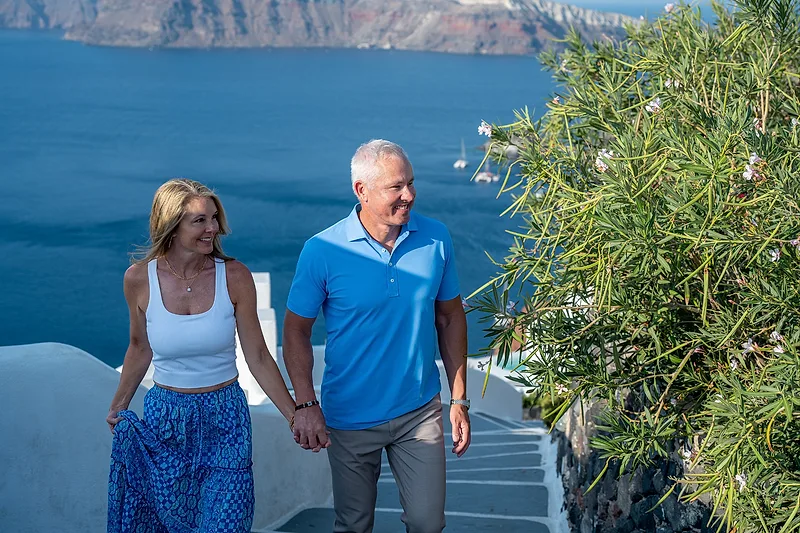 couple walking the steps in santorini