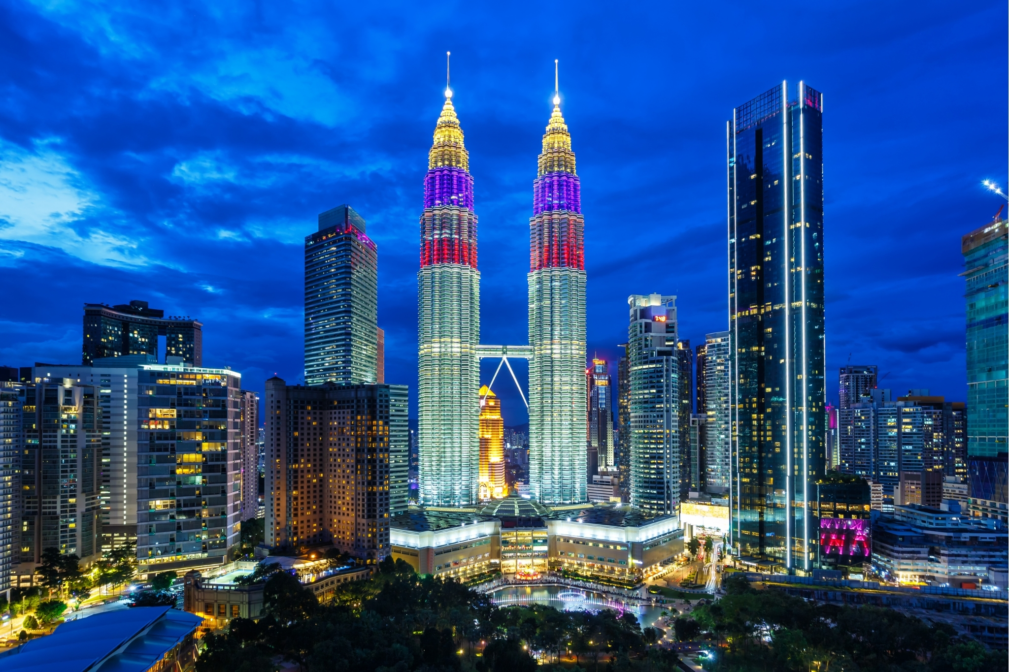 Petronas Twin Towers at blue hour: city lights reflecting in KLCC fountain