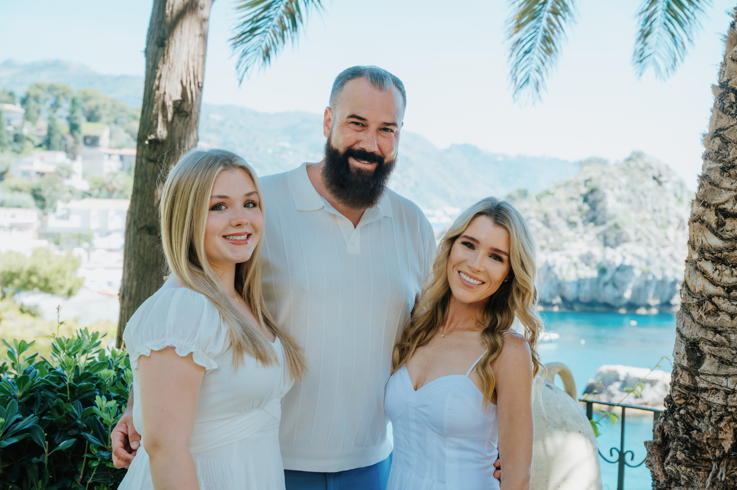 Family dressed in light colors posing in Taormina