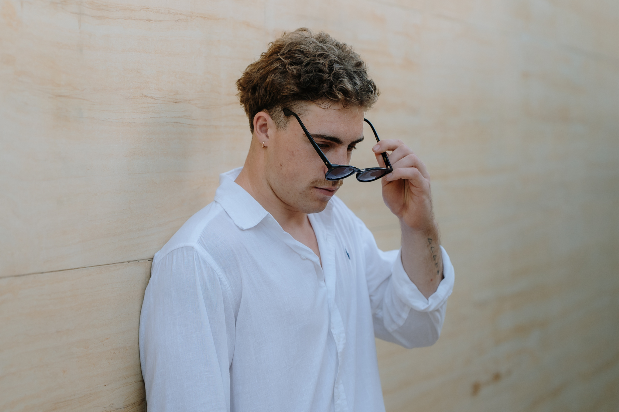 solo photoshoot in nusa dua: boy posing with sunglasses
