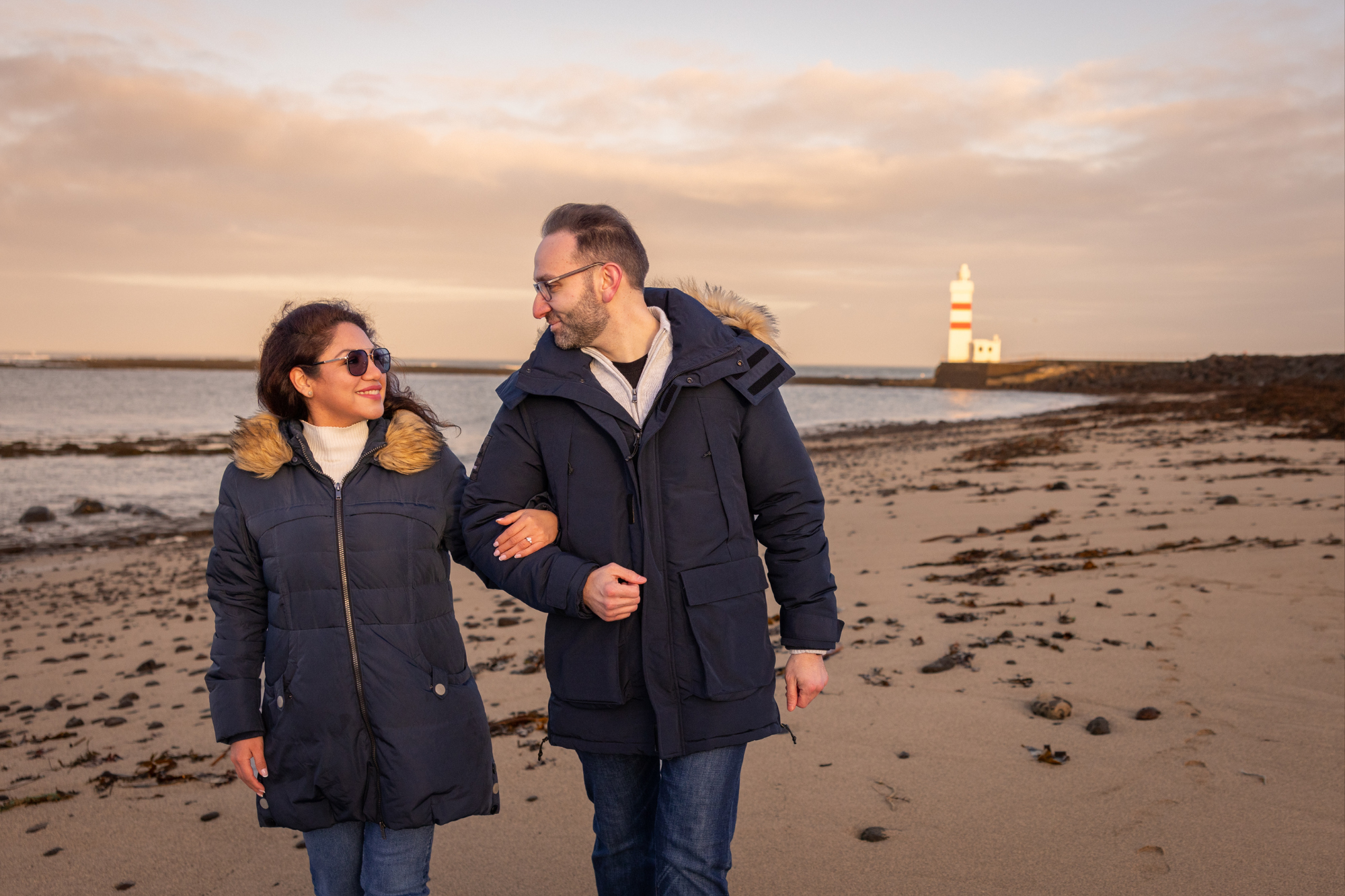 couple walking on the iceland beach during midnight sun